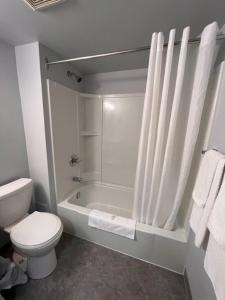 a white bathroom with a toilet and a shower at Kirkfield Motor Hotel in Winnipeg