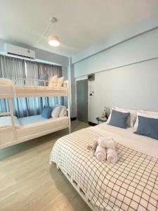 um quarto com 2 beliches e um animal de peluche numa cama em Triple J hotel Trang em Trang