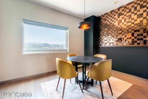 uma sala de jantar com uma mesa e cadeiras e uma janela em Luxurious Studio w/ City Views From the 46th Floor em Cidade do México