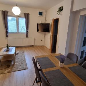 uma sala de estar com uma mesa de jantar e uma televisão em Apartment and rooms Corina em Bilje
