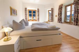 a bedroom with a bed and a desk and windows at Peter - a87525 in Mittenwald