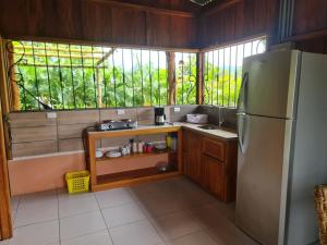 una pequeña cocina con nevera y ventana en Cabin in La Fortuna : Ceiba Eco Container, en Fortuna