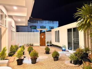a courtyard with potted plants in front of a building at Triple J hotel Trang in Trang