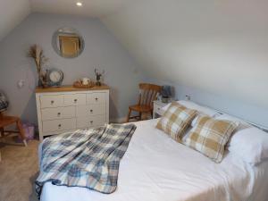 a bedroom with a bed with a dresser and a mirror at southview in Portskerra