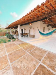 an outdoor patio with a hammock on a house at Casa com piscina praia da Barrinha-CE in Barrinha