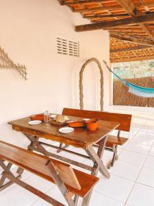 a wooden table with bowls and plates on it at Casa com piscina praia da Barrinha-CE in Barrinha