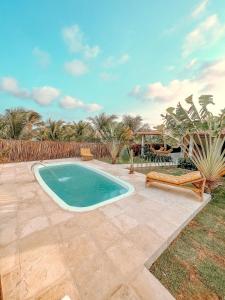 a swimming pool in a yard with a patio at Casa com piscina praia da Barrinha-CE in Barrinha