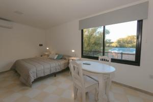 a bedroom with a bed and a table and a window at Aguamansa Apart in Potrero de los Funes +47 photos