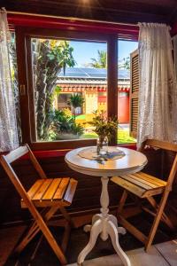 een tafel en 2 stoelen in een kamer met een raam bij Pousada Mar de Dentro in Florianópolis