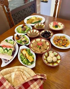 una mesa con muchos platos de comida. en Al-jabal castle Hotel - Ajloun en Ajloun