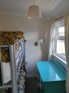 a small room with a bunk bed and a blue desk at B8 lovely chalet in Mablethorpe