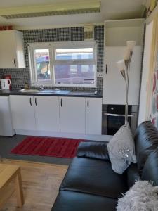 a living room with a couch and a kitchen at B8 lovely chalet in Mablethorpe