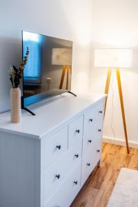 a white dresser with a mirror and a lamp at Ferienwohnung in bester Lage 1 in Rust