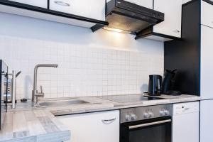 a kitchen with white cabinets and a sink at Ferienwohnung in bester Lage 1 in Rust +3 photos