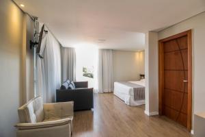 una camera d'albergo con letto, divano e sedia di Pousada Molinha a Penha