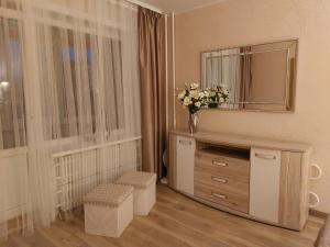 ein Badezimmer mit einer Kommode mit einem Spiegel und Blumen in der Unterkunft Patogus poilsis prie ežero/Comfortable rest in Visaginas