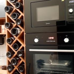 a wall of wine bottles next to an oven at Near Yerevan Serlinhouse in Oshakan