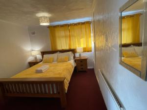 a bedroom with two beds and a mirror in it at Holiday Home Cardiff City Sleeps 7 in Cardiff