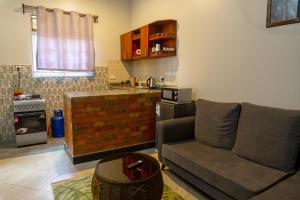 ein Wohnzimmer mit einem Sofa und einer Küche in der Unterkunft FARANT Homes in Kampala