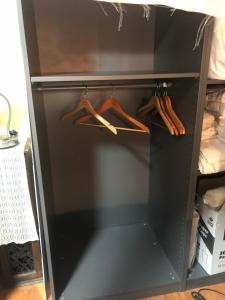 a black closet with wooden hangers in it at Studio with private bath room in Chicago