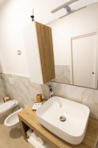 ein Badezimmer mit einem weißen Waschbecken und einem WC in der Unterkunft Liv it - Guest House in Bari