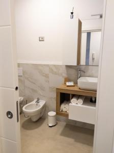ein weißes Bad mit einem Waschbecken und einem WC in der Unterkunft Liv it - Guest House in Bari