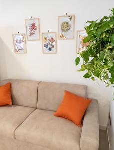 eine Couch in einem Wohnzimmer mit Bildern an der Wand in der Unterkunft Liv it - Guest House in Bari
