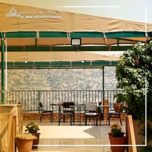 a patio with a table and chairs under a canopy at Al-jabal castle Hotel - Ajloun in Ajloun