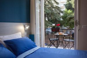 a bedroom with a bed and a balcony with a table at B&B Morelli Home in Cosenza
