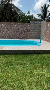 una piscina blu accanto a un muro di pietra di Pousada Mar & Sol a Tutóia