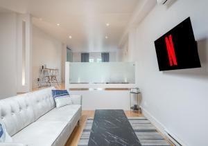 salon z białą kanapą i obrazem w obiekcie Loft The White Pearl Plateau-Mont-Royal 3 Beds w Montrealu