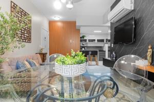 ein Wohnzimmer mit einem Glastisch und einer Topfpflanze in der Unterkunft Residencial Altos da Bela Vista in Gramado