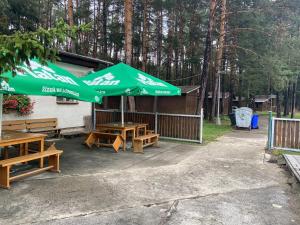a group of picnic tables with a green umbrella at Soukeník FCT in Sezimovo Ústí