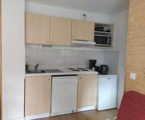 a small kitchen with white cabinets and a sink at les chalets de puy st vincent in Puy-Saint-Vincent +21 photos