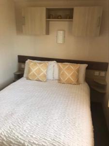 una camera da letto con letto, lenzuola e cuscini bianchi di 20 The Green a Jedburgh