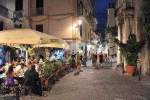 een groep mensen die 's nachts aan een tafel op straat zitten bij CASETTAZZURRA in Amalfi