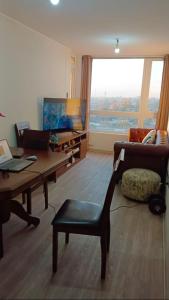 ein Wohnzimmer mit einem Tisch, einem Sofa und einem TV in der Unterkunft Habitaciones en Departamento Centro de Chillan in Chillán