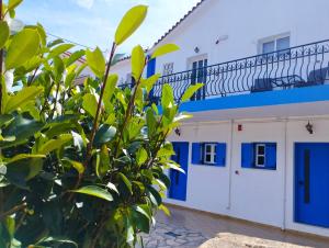 a building with blue doors and a tree at spasmata houses in Minia