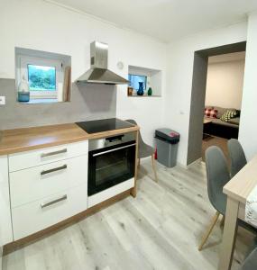 豪洛尼馬拉烏巴的住宿－Apartmán pod vlekem，厨房配有白色橱柜和炉灶烤箱。