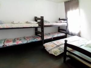 a room with three bunk beds in it at Pousada Bom Jesus in Ponta Grossa