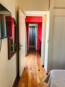 un pasillo que conduce a una habitación con paredes rojas en Departamento a 1 cuadra de calle Aristides en Mendoza