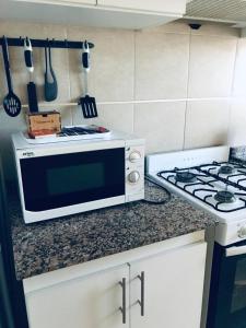 a kitchen counter with a microwave and a stove at Departamento a 1 cuadra de calle Aristides in Mendoza