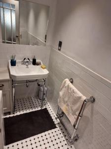 een witte badkamer met een wastafel en een spiegel bij Stylish-Brockley-Entire Place in Londen