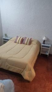 Casa Norte في سالتا: سرير كبير في غرفة بها طاولتين ومصباح