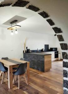 Habitación con mesa, sillas y cocina. en LE MAZOT-SPA HIVER ET ETE-Piscine-Proche lac-Charme-Détente, en Lathuile