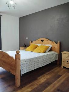 1 dormitorio con cama de madera y almohadas amarillas en LE MAZOT-SPA HIVER ET ETE-Piscine-Proche lac-Charme-Détente, en Lathuile