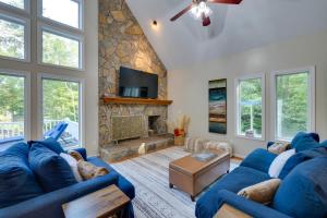 ein Wohnzimmer mit zwei blauen Sofas und einem Steinkamin in der Unterkunft Waterfront Hartfield Vacation Rental with Dock! 