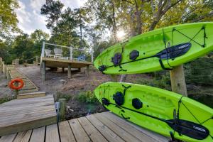 two green kayaks sitting on a wooden deck at Waterfront Hartfield Vacation Rental with Dock! in Hartfield