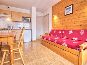 a living room with a red couch and a table at Appartement Flumet, 2 pièces, 4 personnes - FR-1-505-112 in Flumet