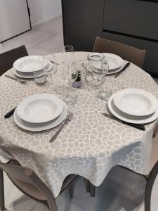 una mesa con platos y copas de vino. en AL PONTE design apartment en Conegliano
